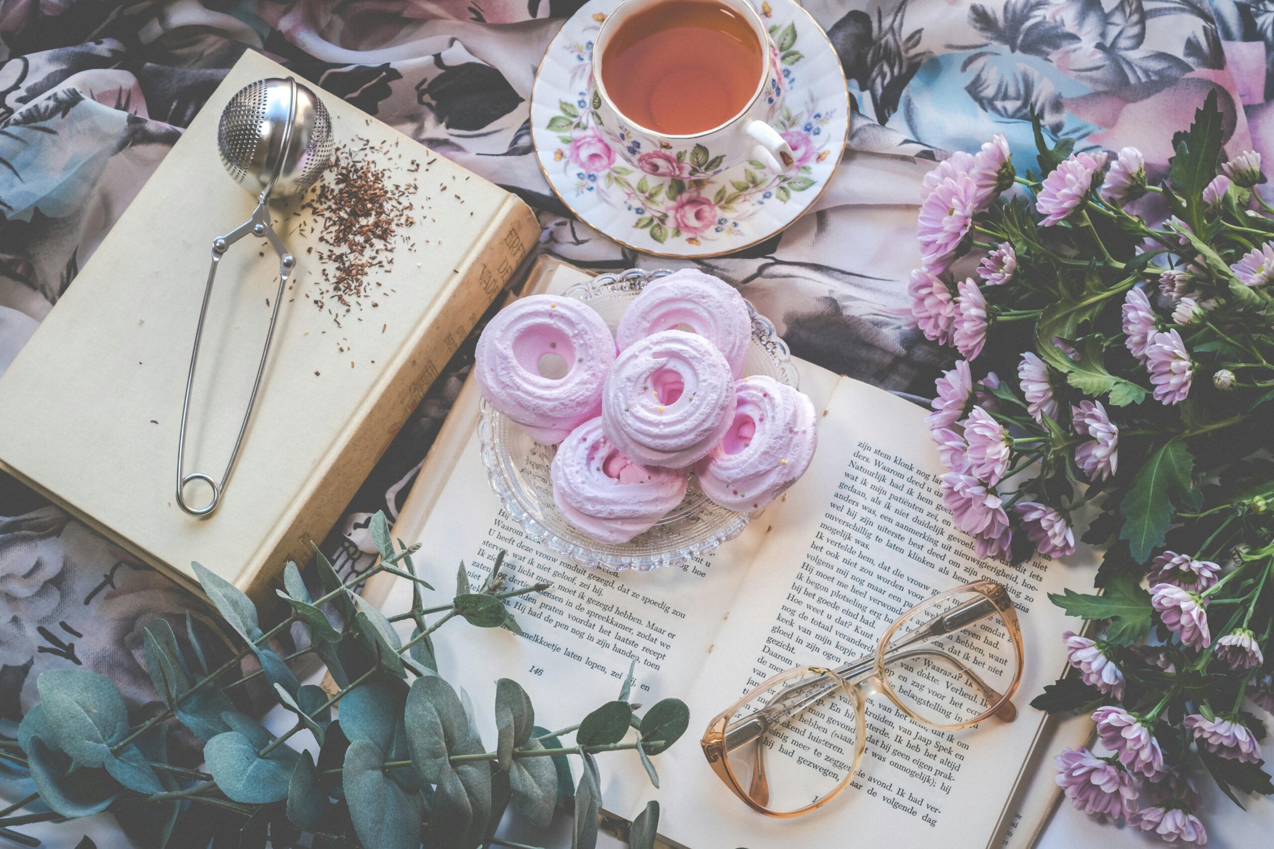 Pexels image of desserts, flowers, and a cup of tea on top of an open book.